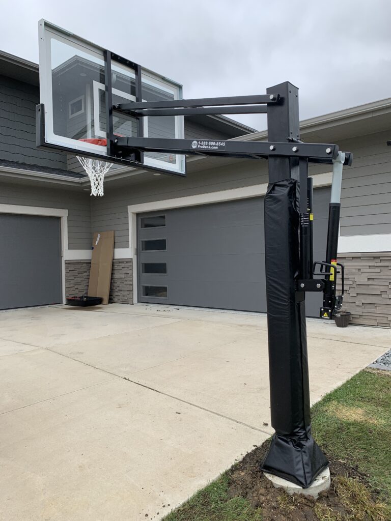 Professional in-ground basketball hoop installation with a concrete base and adjustable backboard in Sioux Falls, SD.