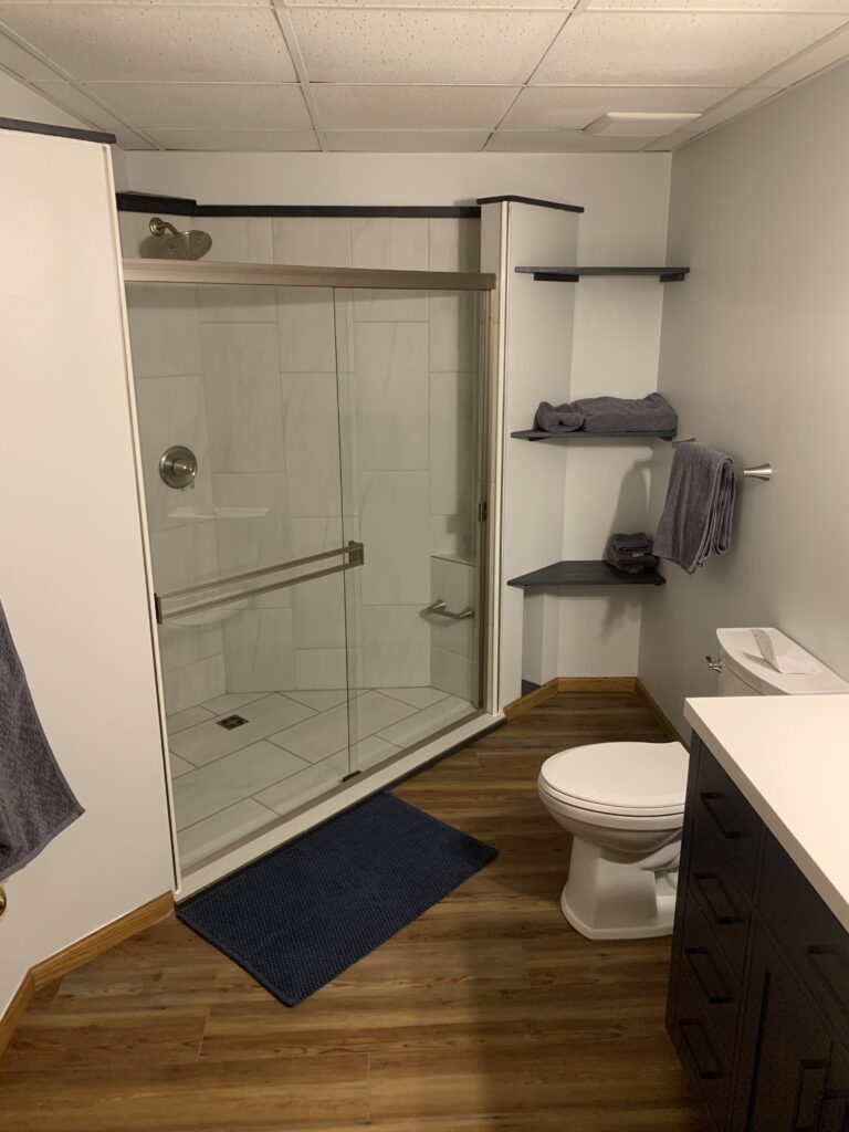 High-end bathroom renovation featuring a custom tiled walk-in shower, glass enclosure, and modern fixtures in Lennox, SD.
